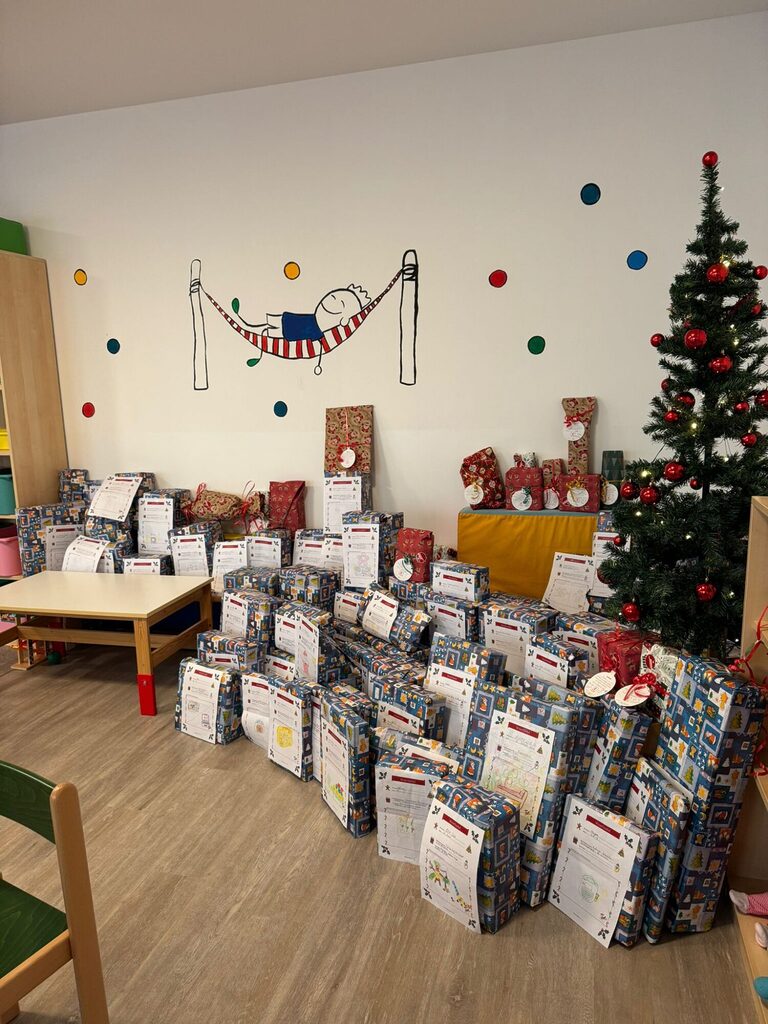 Ein Stapel aus vielen Geschenken mit den jeweiligen Wunschzetteln der Kinder in Bochum angeklebt und einem Weihnachtsbaum. Finanziert wird die Spendenaktion über Spenden an bedürftige Kinder in Bochum.